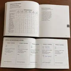 Printed owner's manual and service record booklet showing maintenance schedules